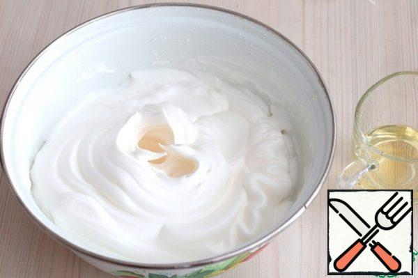 Next, add sugar in portions (80 gr.). Beat the whites with sugar until persistent peaks. Then add vegetable oil (50 gr.). beat the Mixture.