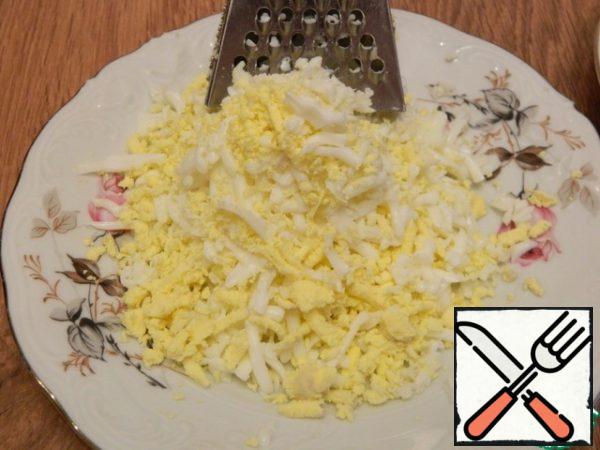 Grate the eggs on a medium grater.