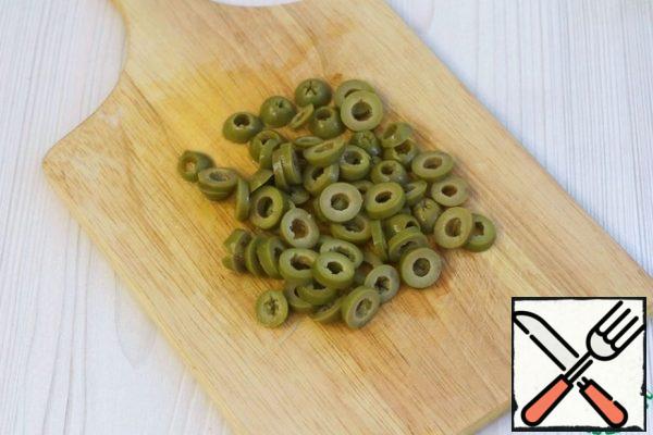 Cut the canned olives into rings.