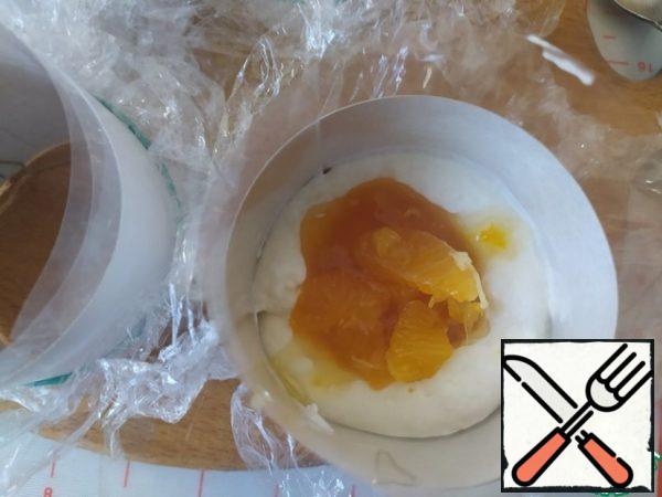 Mango puree is mixed with tangerines and spread on a layer of cheesecake.