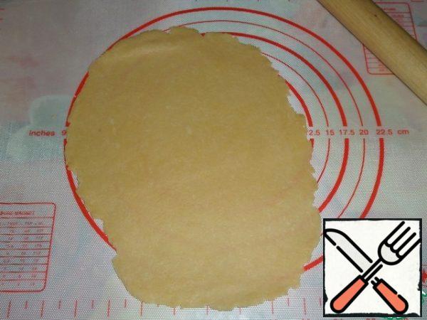 Roll out the dough in the form of a flat cake.
