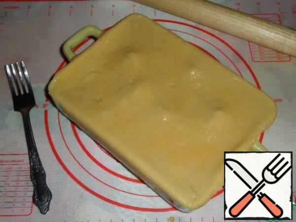 Cover the baking dish with a flat cake. Prick the dough with a fork. Grease with 1 beaten quail egg.