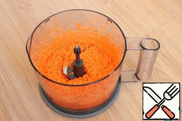 Carrots are crushed in a blender.