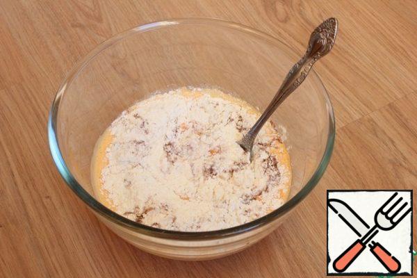 I pour the carrot mixture into a deep bowl. Add flour mixed with baking powder, cinnamon and ginger. I knead the dough.
