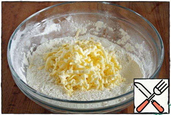 let's start with the dough: in a bowl, sift the flour, add baking powder, sugar and salt, mix well. On a large grater, rub the butter and grind with flour for five minutes, not forgetting to make energetic gestures to the beat of music...