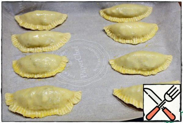 We spread the finished blanks on a baking sheet covered with parchment paper, beat the egg and coat our empanadas on top. We send it to the oven, preheated to 200 degrees for 25-30 minutes.