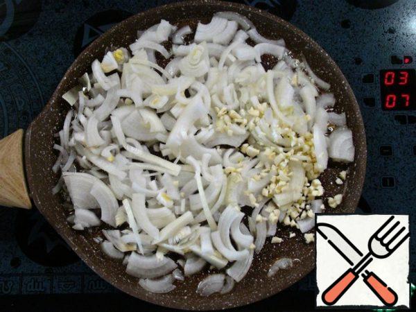 Chop the onion into strips, chop the garlic and fry everything in vegetable oil until golden.