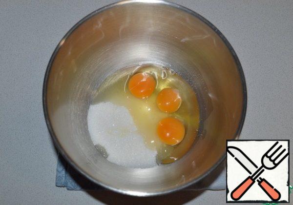 Beat the eggs with sugar into a fluffy foam.