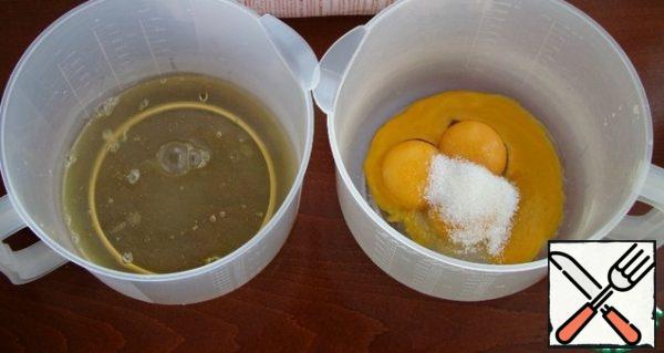 Divide the eggs into whites and yolks. Add half the norm of sugar to the yolks.