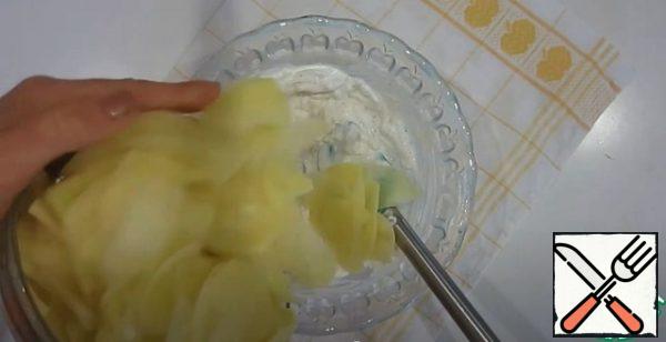 Add sour cream, garlic, pepper, nutmeg and salt to the finely chopped onion. add the potatoes, cut into thin slices. Add grated cheese.