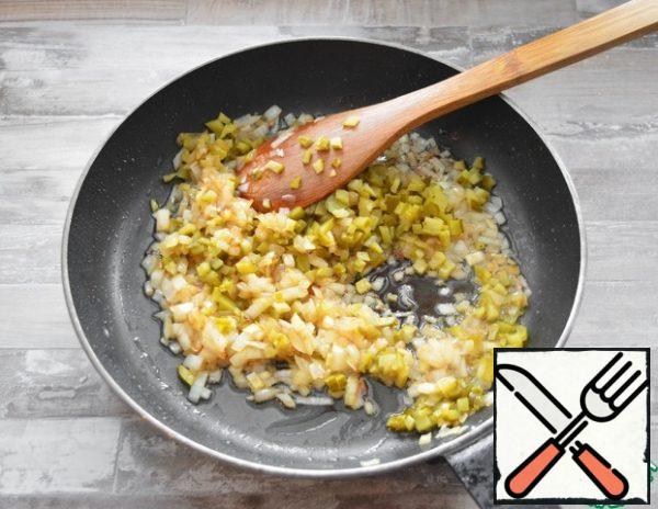 In the same pan, fry the chopped onion (the remaining 200 g) and the chopped pickled gherkins.