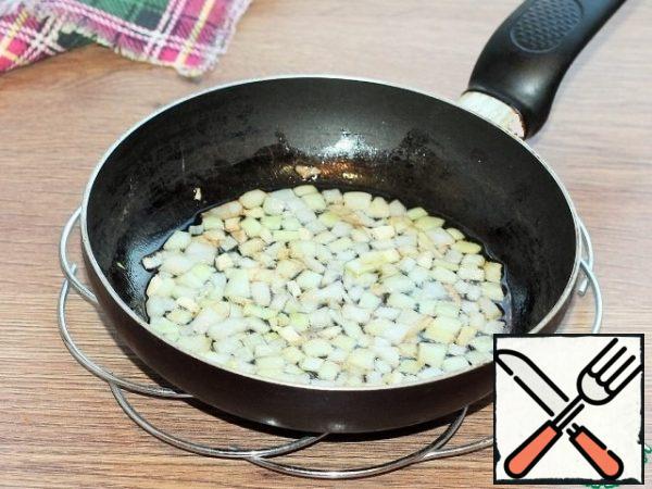 In the preheated oil, fry the onion and garlic until transparent.