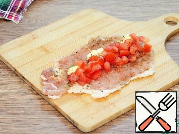 Sprinkle the meat plate with seasoning, salt, pepper and spread the tomato slices. Add the butter. Close the filling with a plate of meat and fix it with wooden toothpicks.
