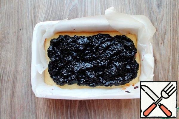 On the surface of the dough, put the jam, I have blueberries with black currants, in an even layer, retreating slightly from the edges.