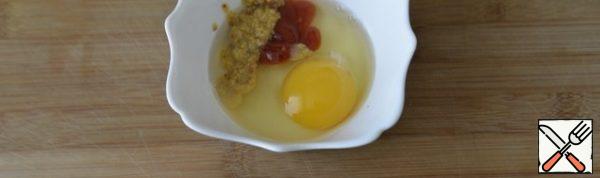 For filling, mix the egg, mustard with grains and ketchup. I have mustard. Mix well, beat with a fork. I want to note that a whole egg is a lot, half is enough.