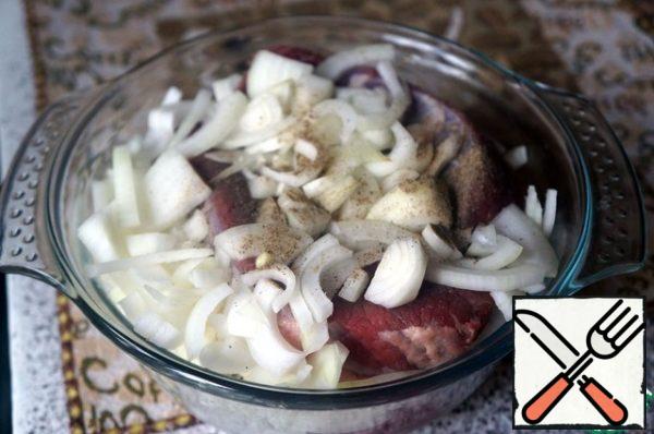 In a container for marinating, put the meat, cover with half the onion, pour in the wine, leave for an hour and a half.