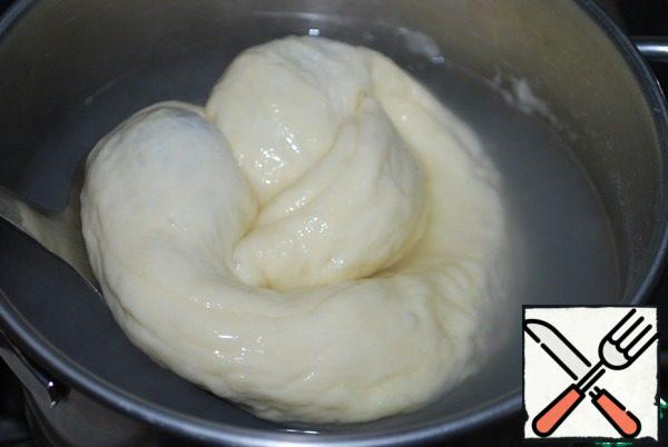 And form a bagel-brezel. Pinch the edges well so that they do not disperse when baking. And even if during baking the chocolate dough will ooze out of the buns, it will only give them beauty. In a bowl, pour hot water and stir in 2 teaspoons of baking soda. Dip each bagel in hot water for 20-30 seconds.
