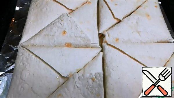 Put the oven to preheat to 180 degrees. At this time, cover the baking sheet with parchment paper. If you took the foil-lubricate with vegetable oil. We spread the envelopes.