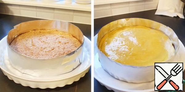 Spread the cream on the surface of the cake.

For lack of anything better, foil was used as a border, which I folded and secured with paper tape around the perimeter of the cake. Instead of foil, it is possible, probably, to use special detachable forms.
