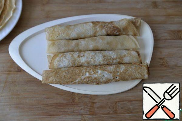 Roll the pancakes into rolls. Store in the refrigerator until serving. Before serving, I advise you to send it to the freezer for 30 minutes, so that it is easier to cut.