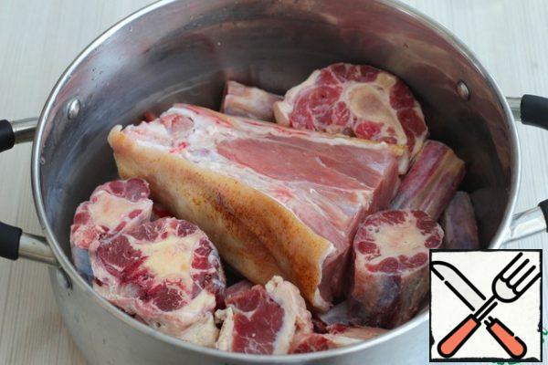 Wash the pork knuckle and beef tail and cut it into pieces. Excess fat can be cut off if desired. In a saucepan, add the chopped beef tail and knuckle, pour cold water and put on an intense heat. When boiling, remove the resulting foam. Cover the pan with a lid, reduce the heat to low and cook the meat for 5-6 hours. 2 hours before cooking, add the onion (whole onion), Bay leaf (2 PCs.), black pepper (1 teaspoon), salt and ground black pepper to taste.