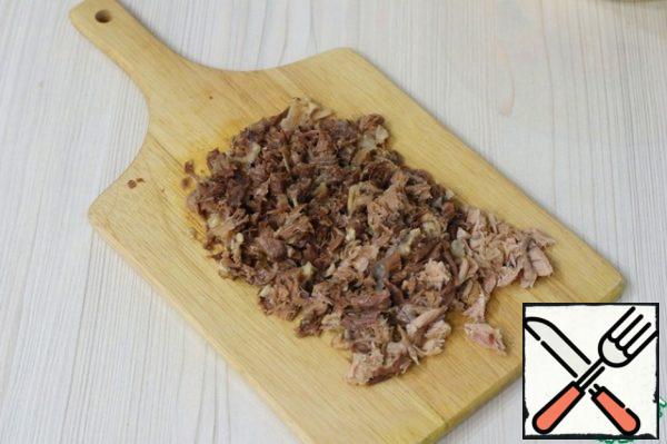 Cool the meat to room temperature and remove from the broth. Strain the broth to avoid getting small bones in the finished dish. Next, part of the meat and skins from the knuckle should be passed through a meat grinder, the rest of the meat should be cut into pieces.