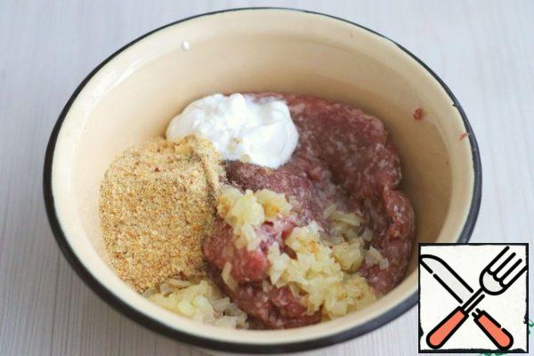 In the finished minced meat, add the passaged onion, breadcrumbs (2 tablespoons), sour cream (1 tablespoon), salt and ground black pepper to taste.