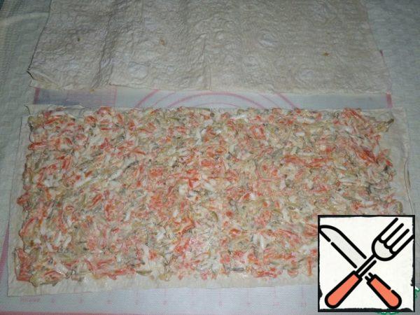 Unpack the pita bread. I will not use the entire sheet, but about 1/3 of the sheet-a rectangle of 38x19 cm.
Spread the prepared filling on the pita bread. Evenly distribute.