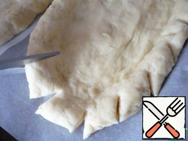 Use scissors to make oblique cuts on the sides of the pizza.