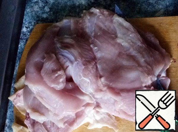 I cook from home-made broiler chicken. It weighed 2.5 kg. I separate the breast along with the skin and cut it lengthwise into layers. Breast tightened by 850 g. I carefully remove the skin from the hams (we will need it), separate the meat from the bones.
All parts of the meat RUB with salt (I have Svan).