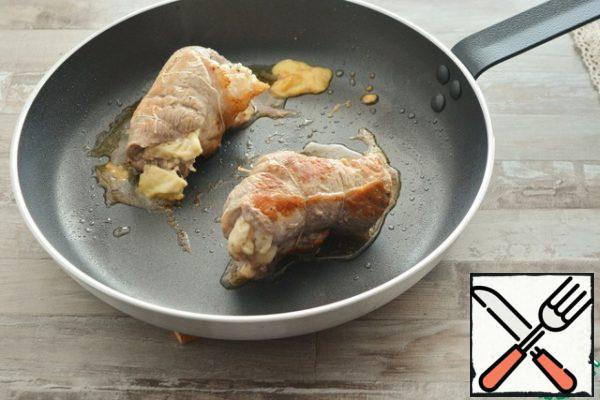 Fry in a preheated frying pan in oil on all sides. Bring to readiness in preheated to 200° C . In the oven for about 10-15 minutes. To avoid drying out when baking in the oven, cover the rolls with foil. Do not forget to remove the threads before serving.