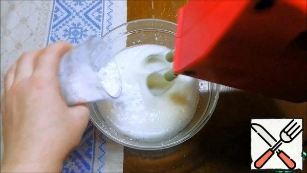 Separately, in a clean and dry bowl, lightly add salt and start whipping 4 egg whites at a low speed. As soon as we get a plentiful foam mass, add powdered sugar in portions. Whisk until "strong peaks".