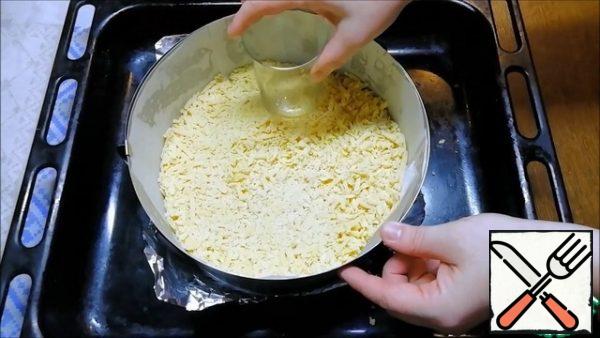 At this time, one of the parts of the dough is rubbed on a large grater directly into the mold, leveled and slightly compacted.