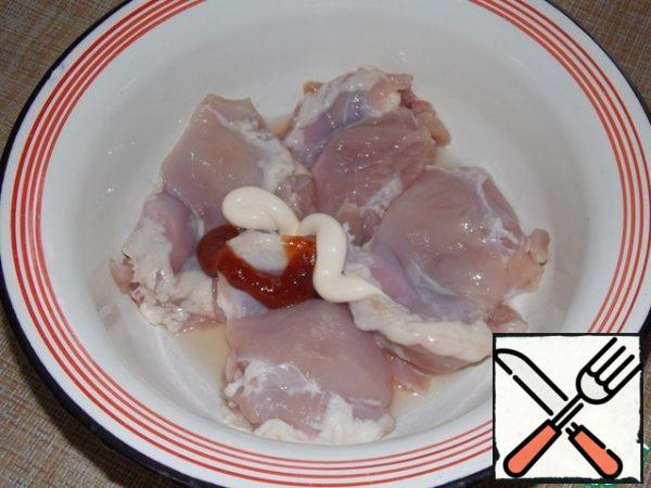 Wash chicken thighs, remove the skin. Put in a bowl, pour in the oil. Add mayonnaise and ketchup.