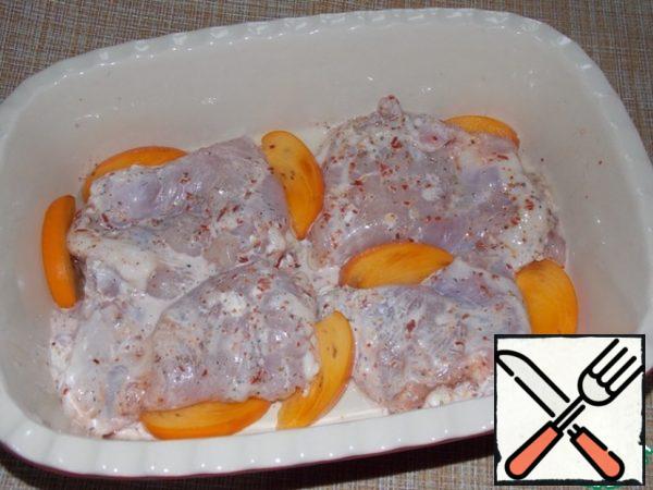 Place the thighs in a greased baking dish. Arrange the pieces of persimmon, cut into small slices.