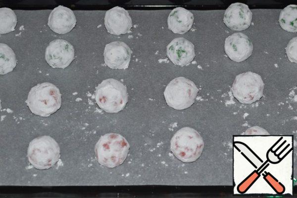 Roll the dough into balls the size of a quail egg.
Roll them in powdered sugar and place them on a baking sheet covered with parchment, at a distance from each other.