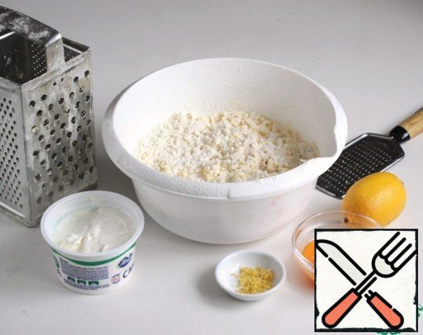 To the butter-flour mixture, add sour cream, egg yolks, lemon zest, knead the dough.