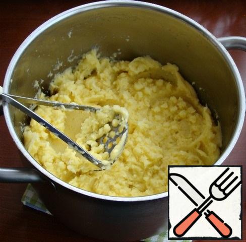 While the meat part of the pie is baked, prepare mashed potatoes.
To do this, boil the potatoes until tender, along with 1 carrot.
Drain the water and add salt, butter, 3 egg yolks to the potatoes and mix everything thoroughly in the puree.