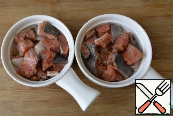 Pickled pieces of fish are laid out in a baking dish or portioned into molds.