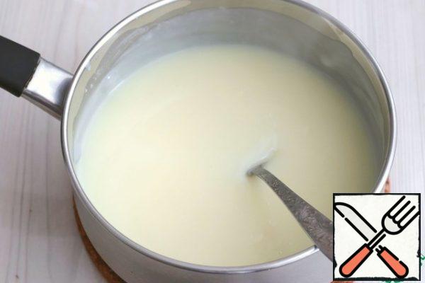 Next, gradually add the milk-pudding base to the hot milk in a thin trickle and, with constant stirring, boil the mixture until it thickens.