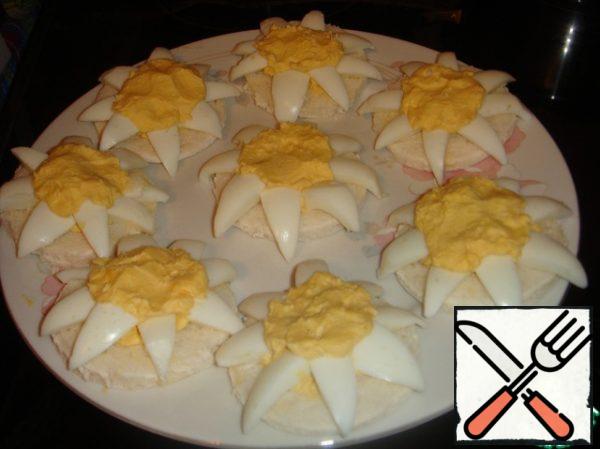 Place 8 "petals" in a circle, immersing a wide part of them in a creamy yolk elevation.
