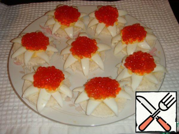 Put a teaspoon of red caviar in the middle of each "flower". You can serve it to the table.