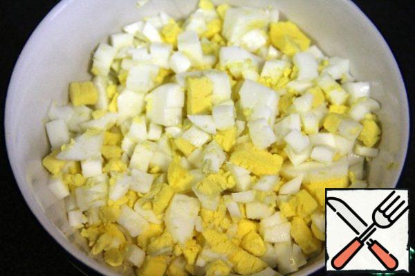 Boil the eggs and cut them into small cubes.