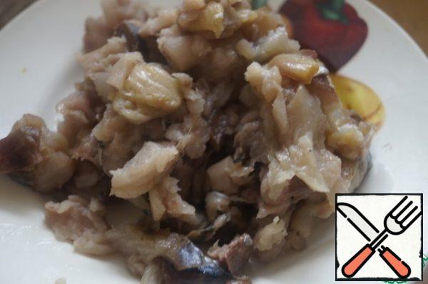 Put the rice to boil in water. Meanwhile, separate the smoked fish from the skin and bones, finely chop.