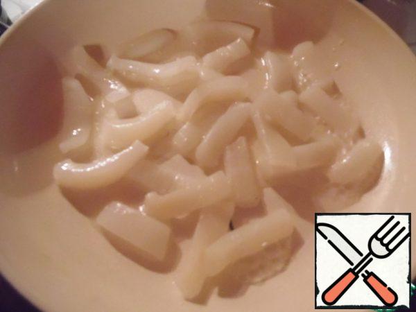 Defrost the squid and peas, cut the squid into small pieces, fry in vegetable oil for 2-3 minutes.