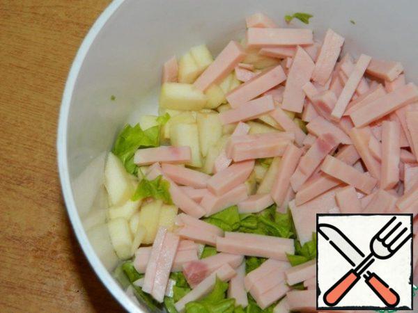 Peel and slice the pears. Add the chopped ham and lettuce leaves.