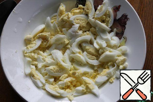 Boil the eggs, peel and cut into strips. Also chop the arugula. In a bowl, mix sour cream with finely chopped garlic, season with salt and pepper.