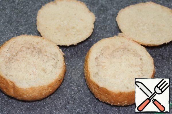 Cut off the tops of the buns, remove the crumb, sprinkle the buns from the inside with vegetable oil.