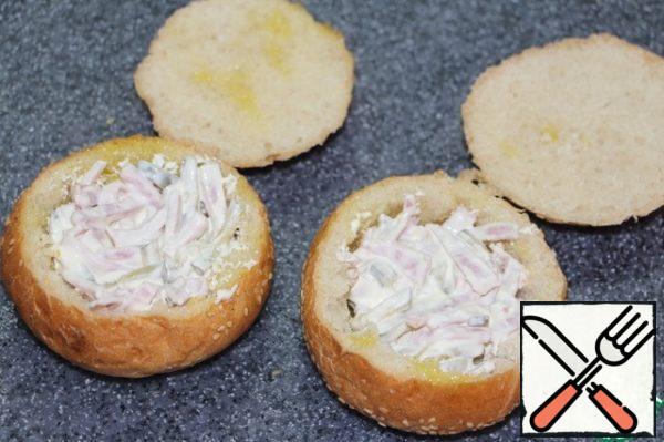 Mix sour cream with mustard, stir and combine with ham and cucumber straws.
Fill the buns with filling.