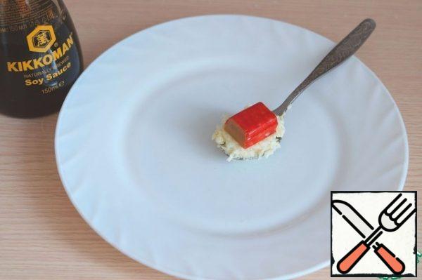 Take a teaspoon of the required amount of cheese-egg mixture, add a cube of crab stick.